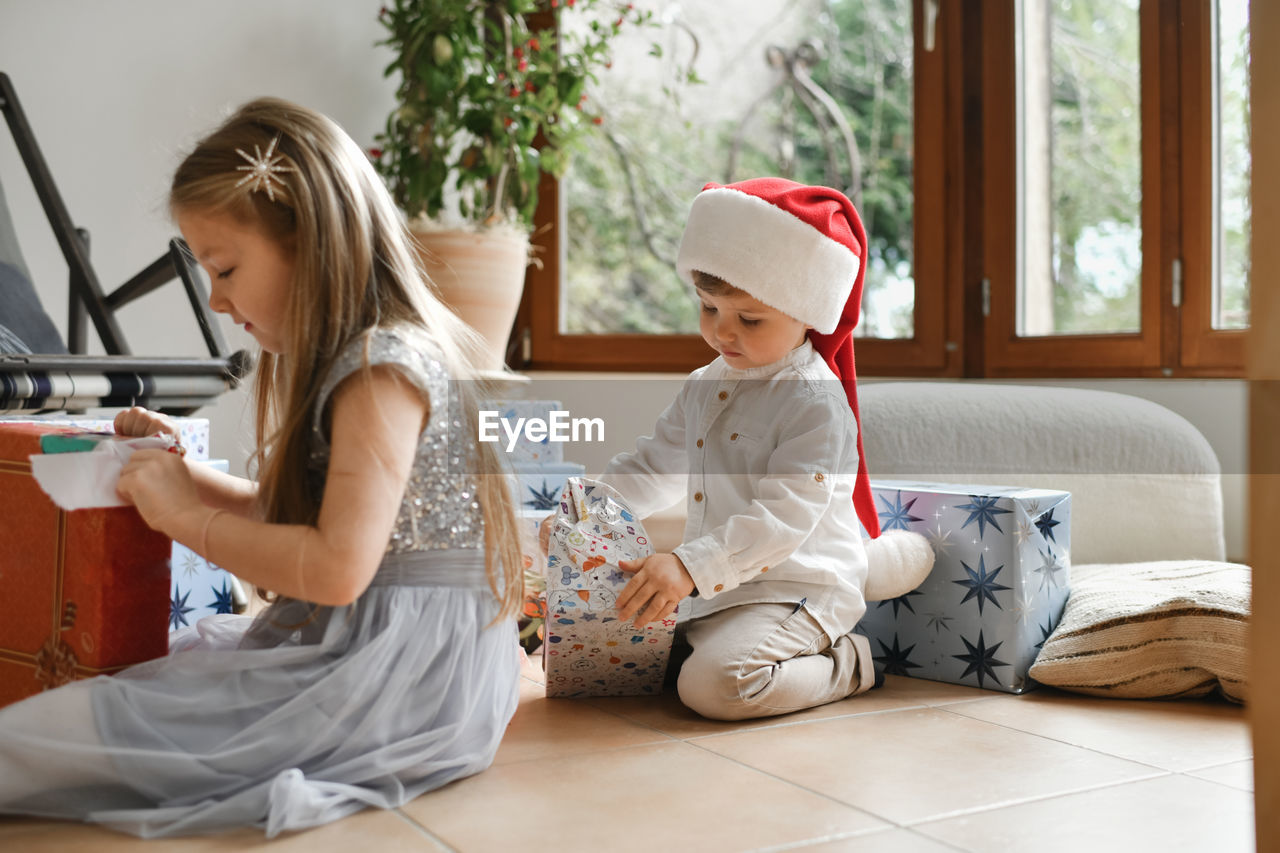 The brother and sister unwrapping christmas presents