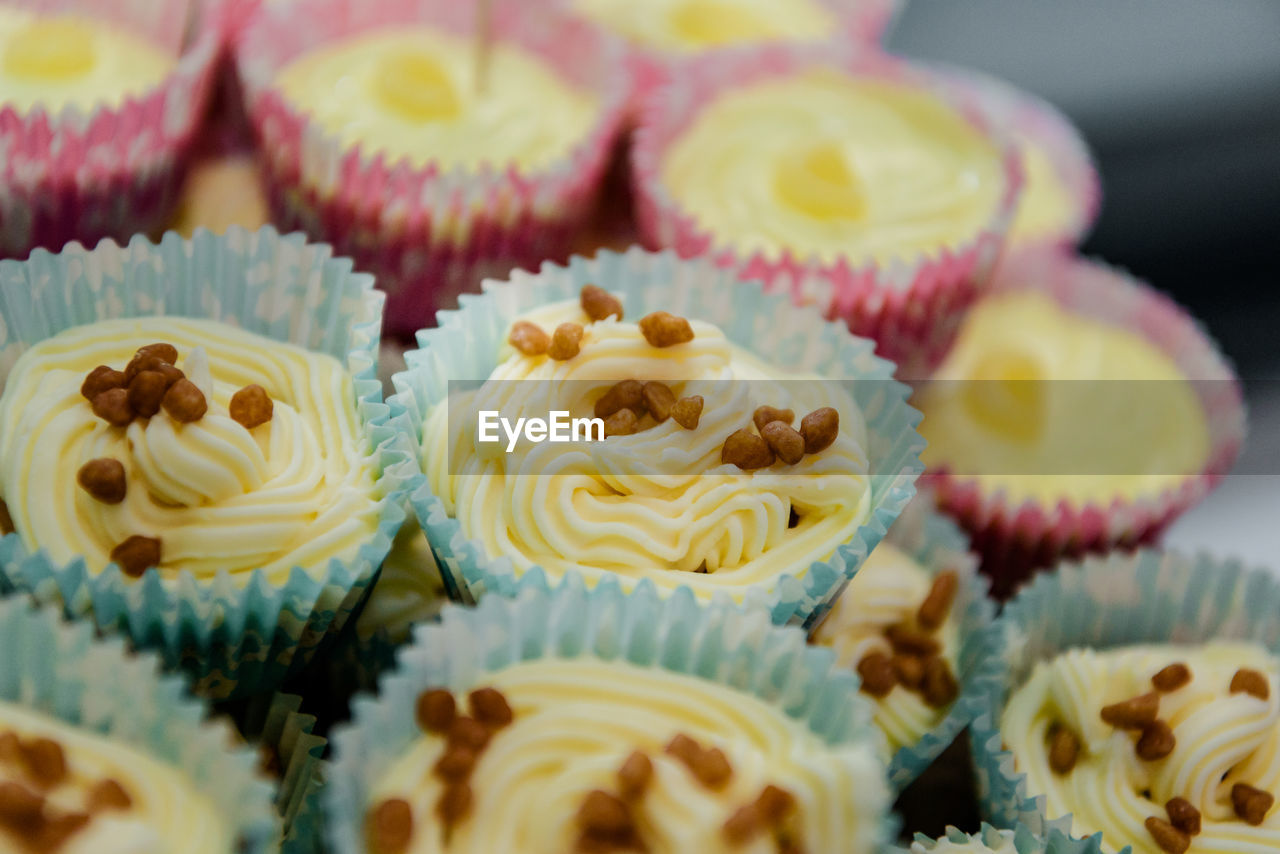 CLOSE-UP OF CUPCAKES ON TABLE AGAINST BLURRED BACKGROUND