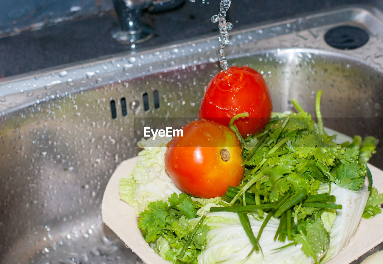 HIGH ANGLE VIEW OF CHERRY TOMATOES IN WATER