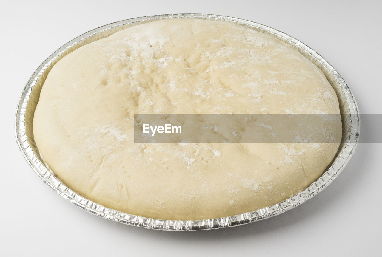 High angle view of dough in container against white background