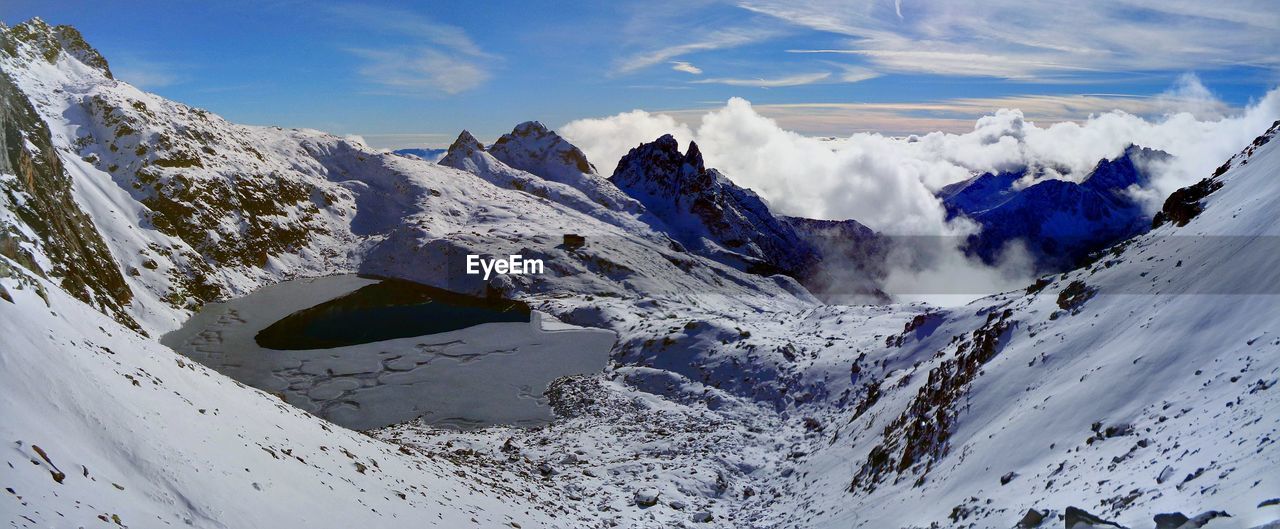 PANORAMIC VIEW OF SNOWCAPPED MOUNTAINS AGAINST SKY DURING WINTER