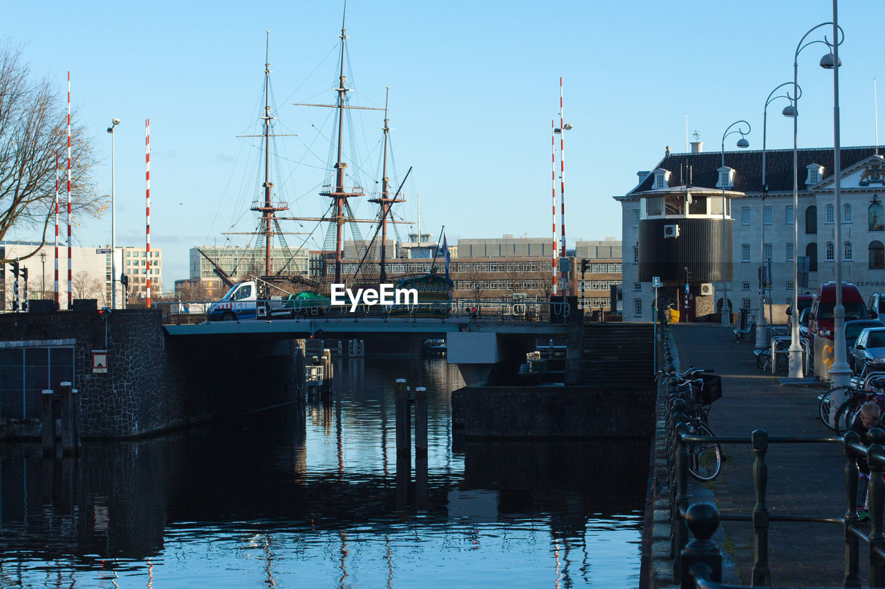 BOATS MOORED AT HARBOR AGAINST CLEAR SKY