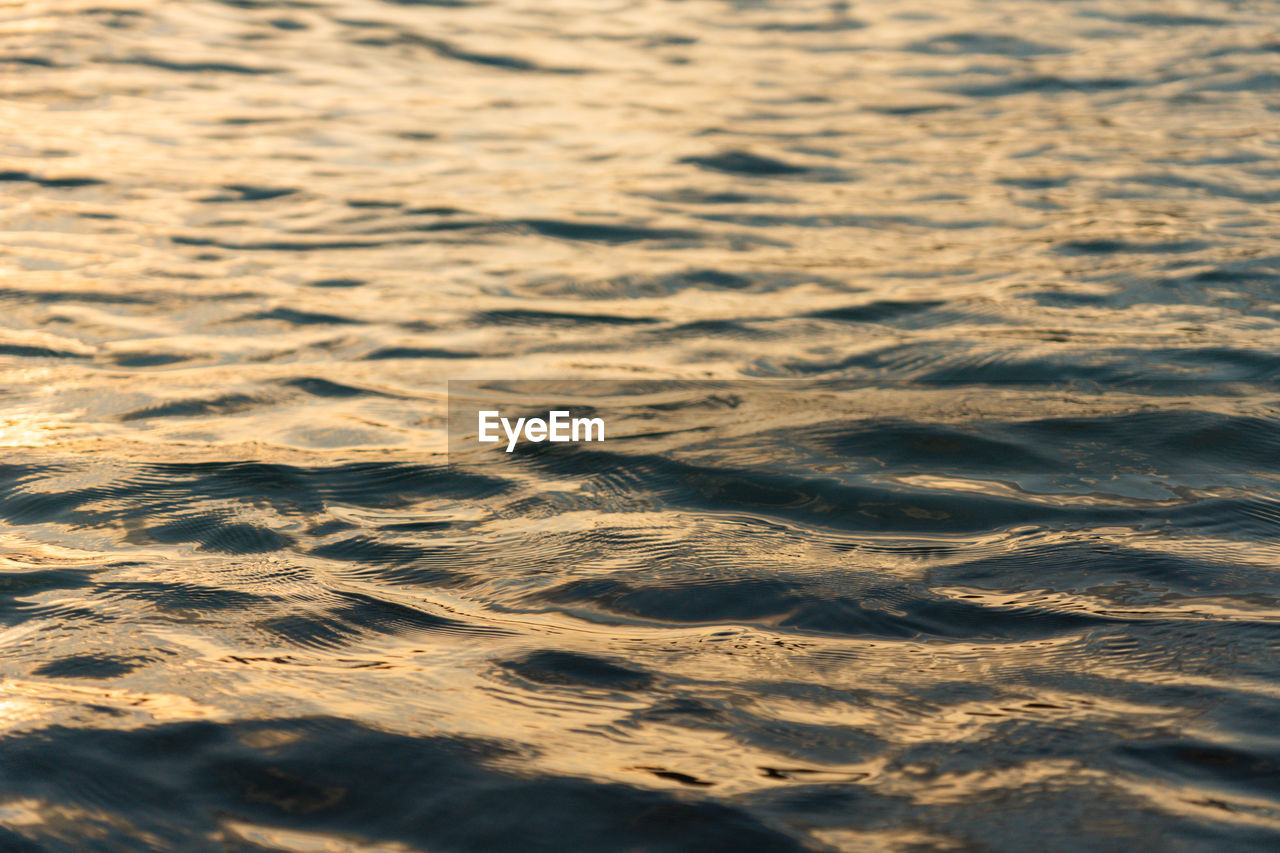 Full frame shot of rippled water in golden evening light