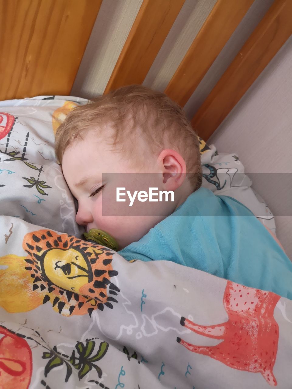 Cute boy sleeping on bed at home