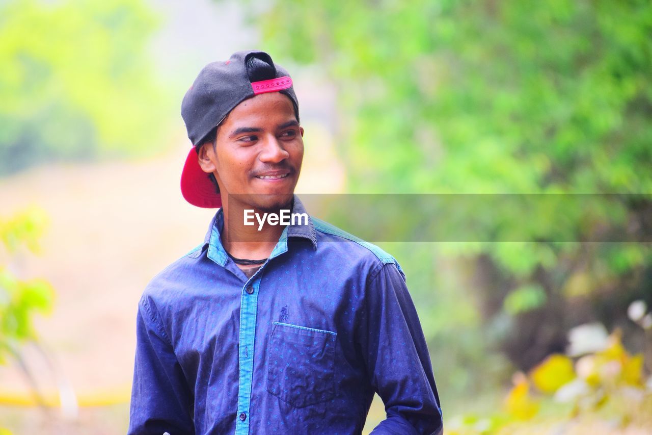 Smiling teenage boy standing outdoors