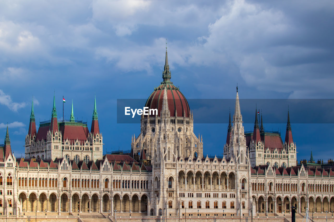 The hungarian parliament in budapest against cloudy sky