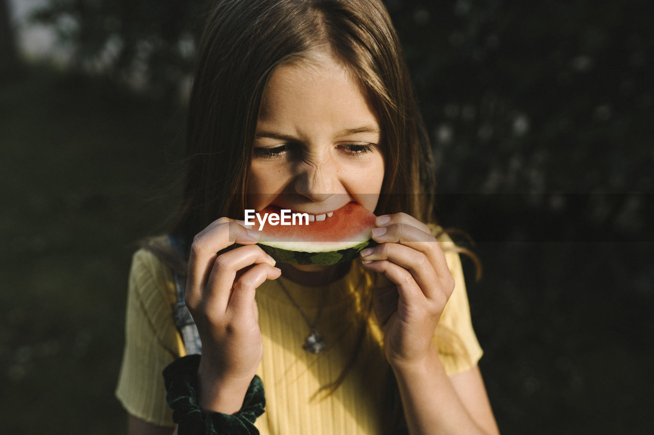 Girl eating watermelon on sunny day