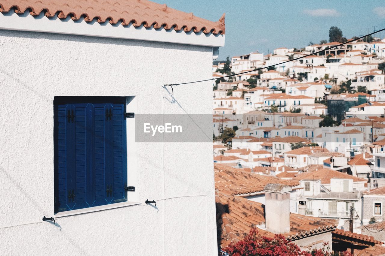 Houses in town against sky during sunny day