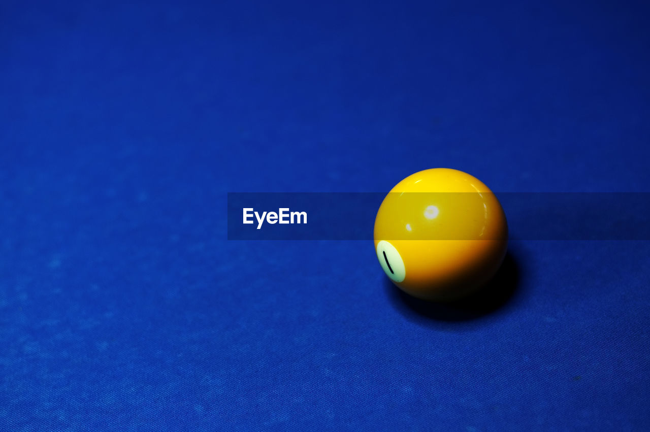 Close-up of yellow ball on pool table