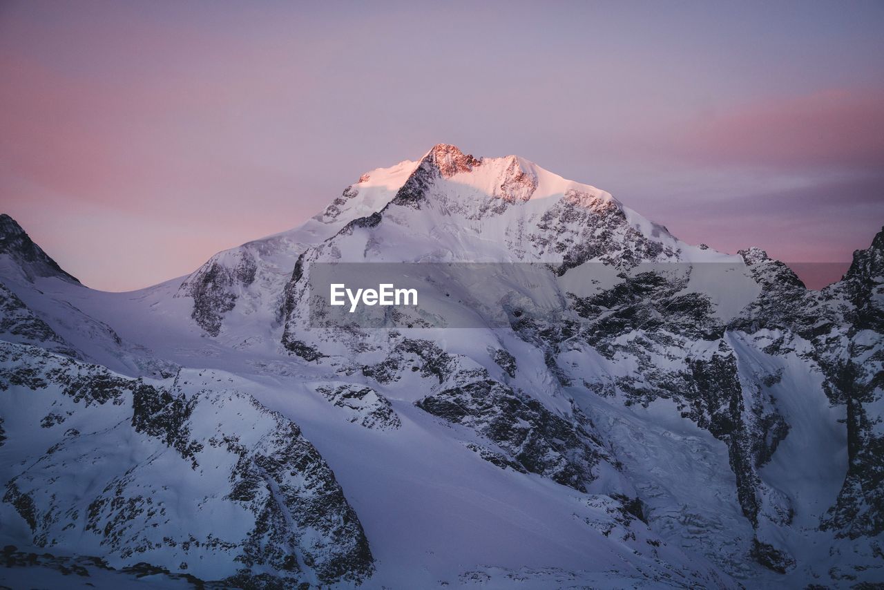 Scenic view of snowcapped mountains against sky during sunset