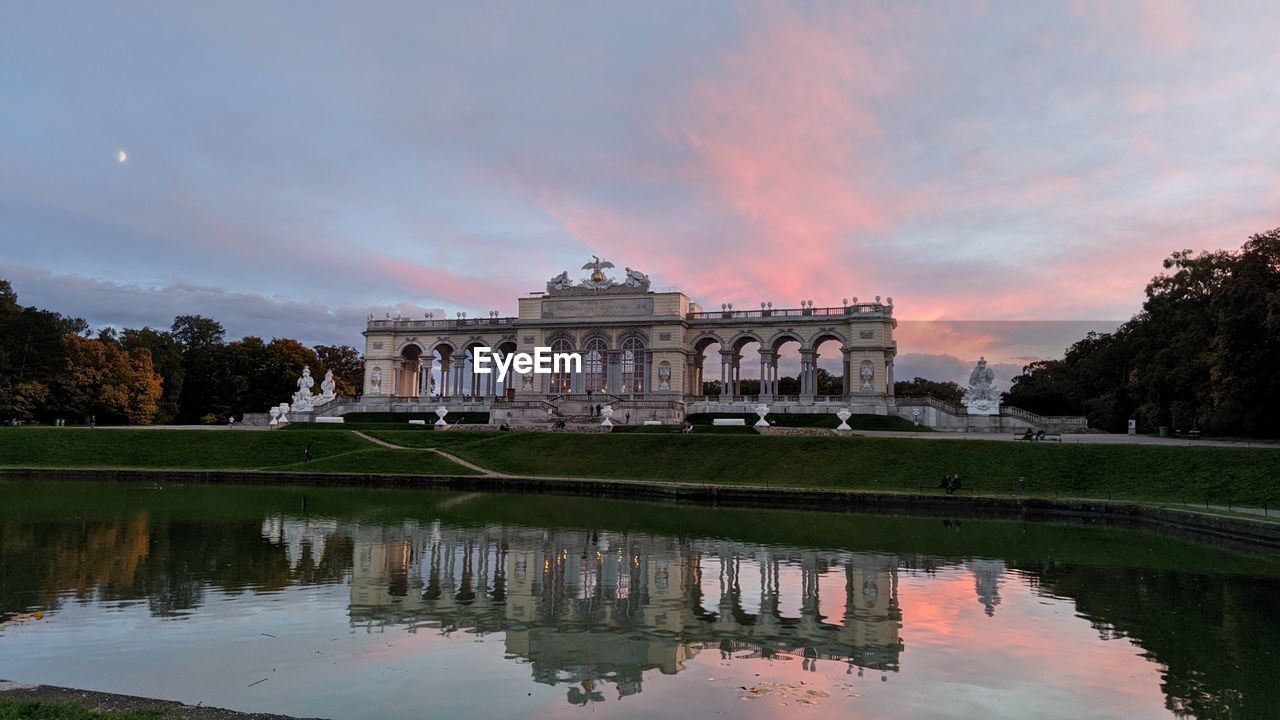 Reflection of building in lake at sunset