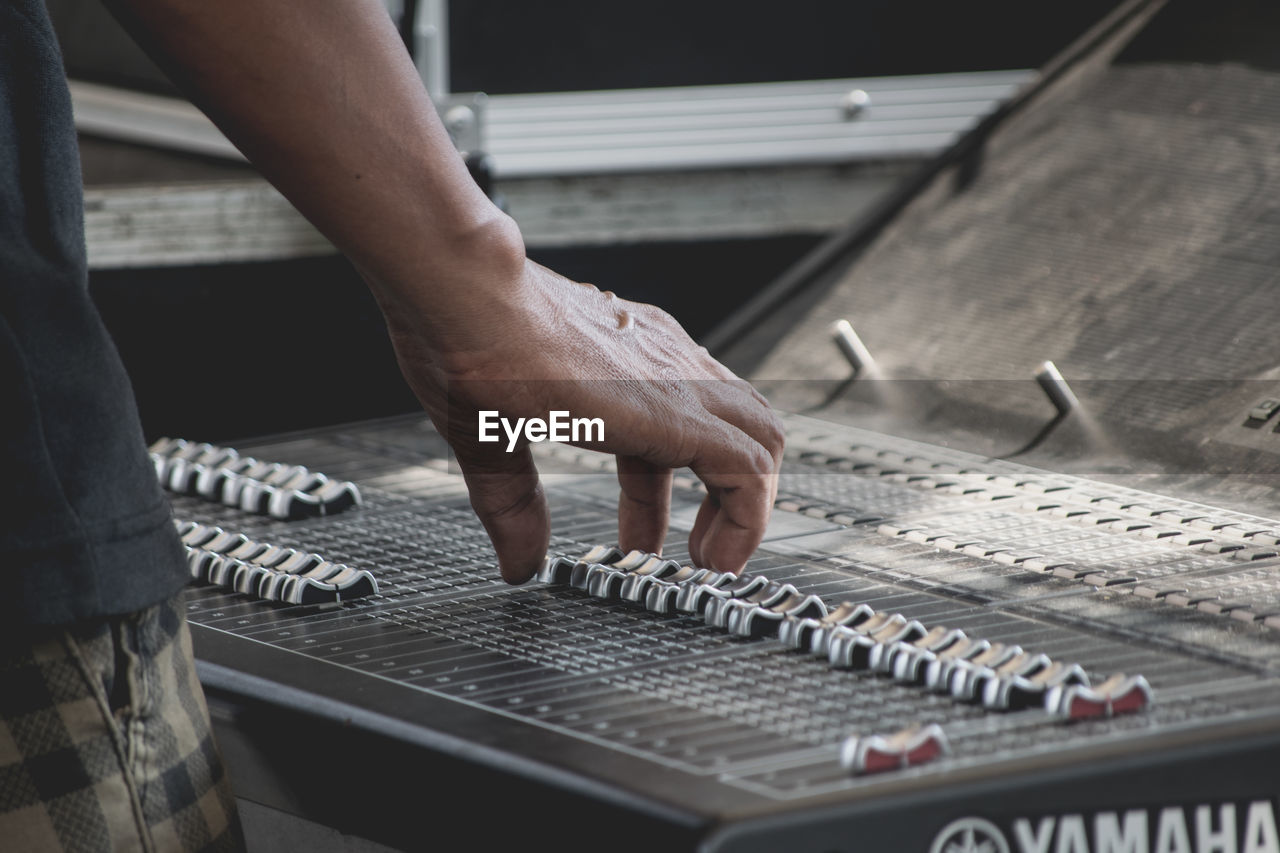 Cropped image of man using sound mixer in studio