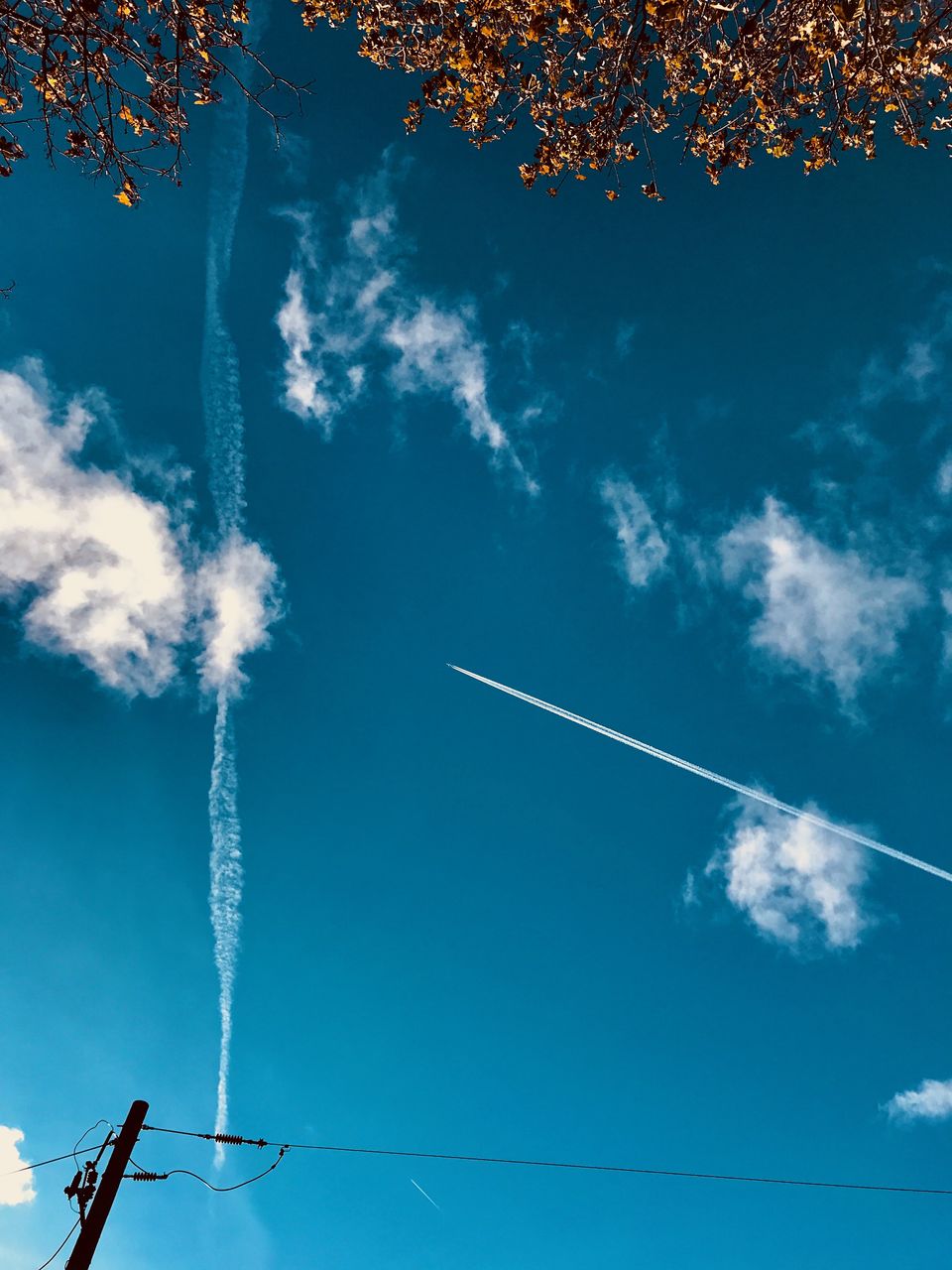 LOW ANGLE VIEW OF VAPOR TRAIL AGAINST BLUE SKY