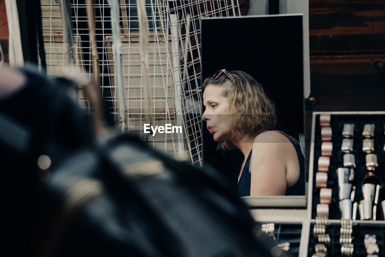 Rear view of woman looking through window