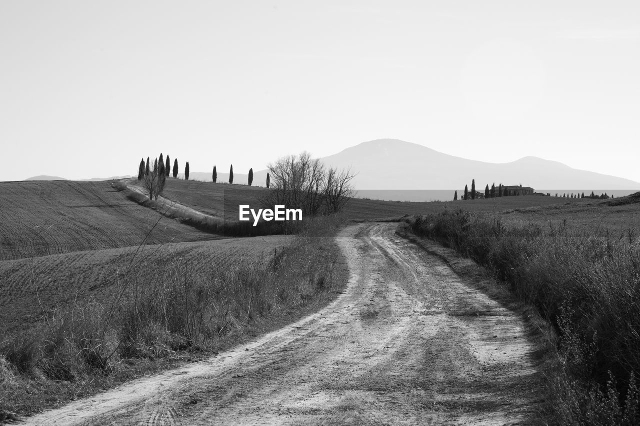 PANORAMIC VIEW OF DIRT ROAD ON FIELD AGAINST SKY