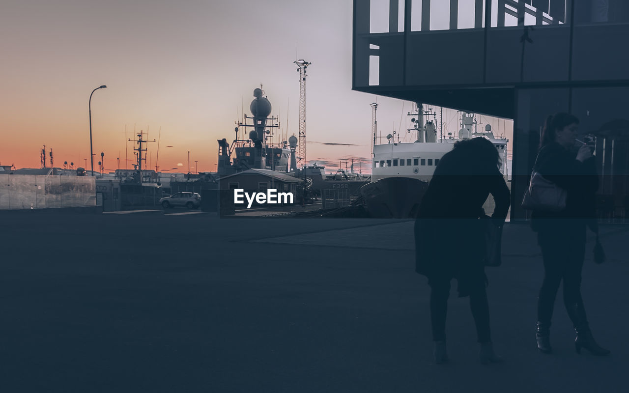 Rear view of woman on road against sky during sunset