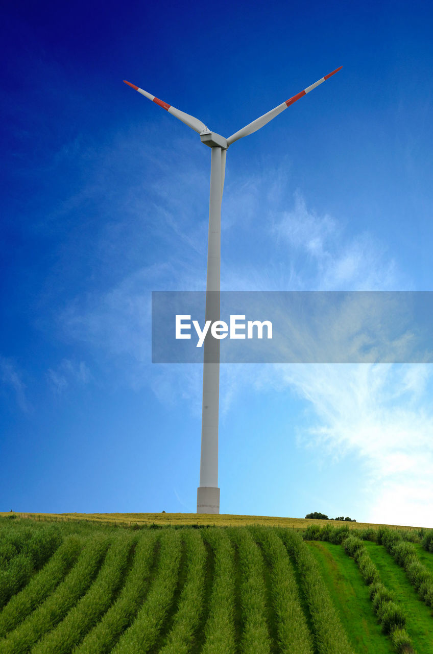 LOW ANGLE VIEW OF WIND TURBINES ON FIELD AGAINST SKY