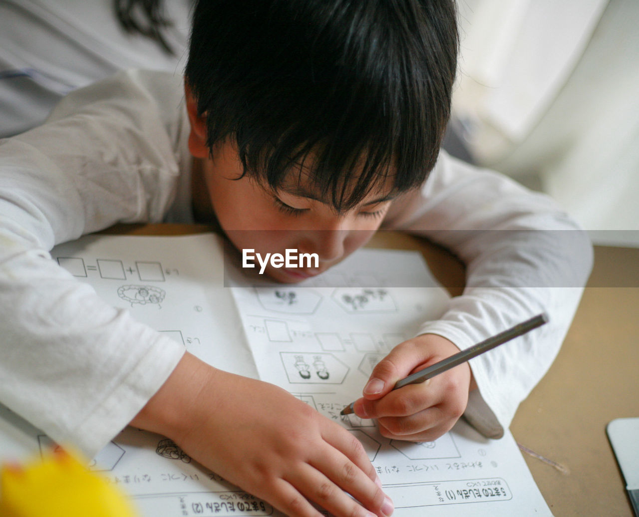 Close-up of boy drawing on blueprint at home