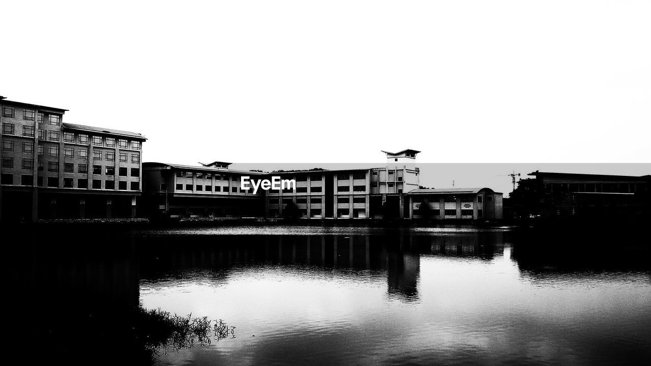 Lake by building against clear sky