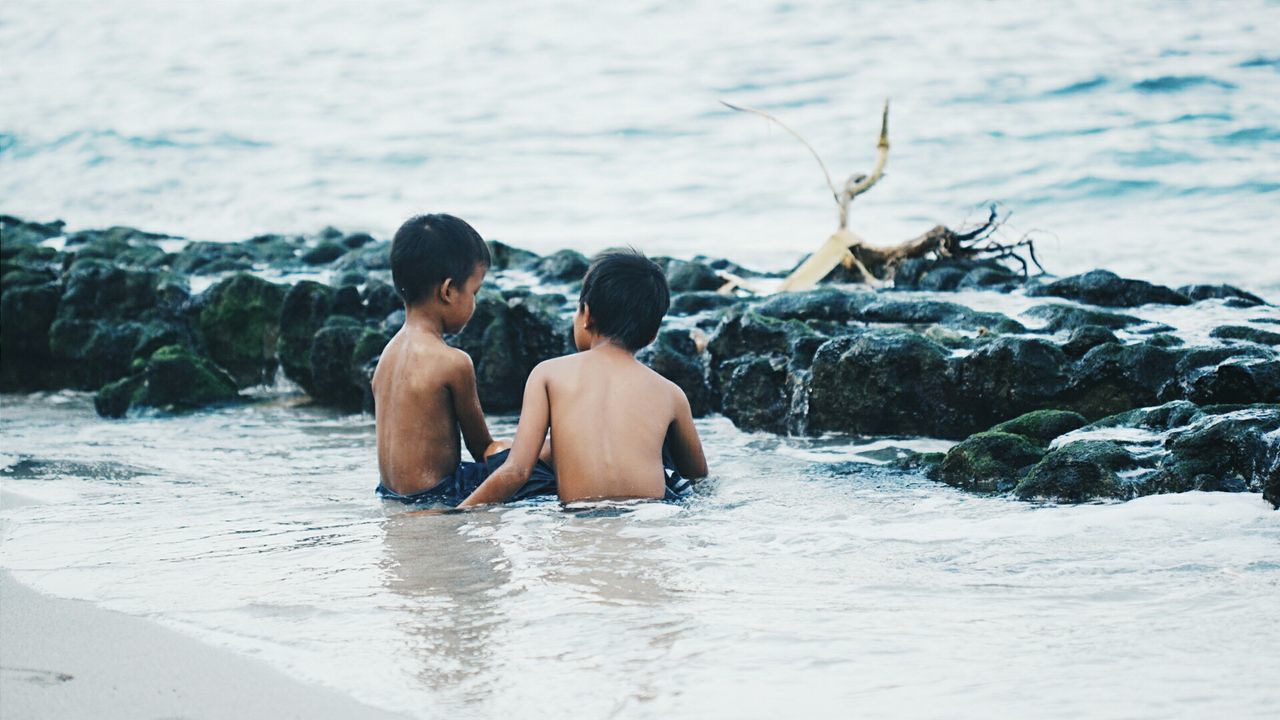 PEOPLE RELAXING ON SHORE AT BEACH