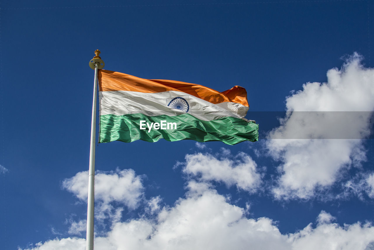 Low angle view of indian flag against blue sky during sunny day