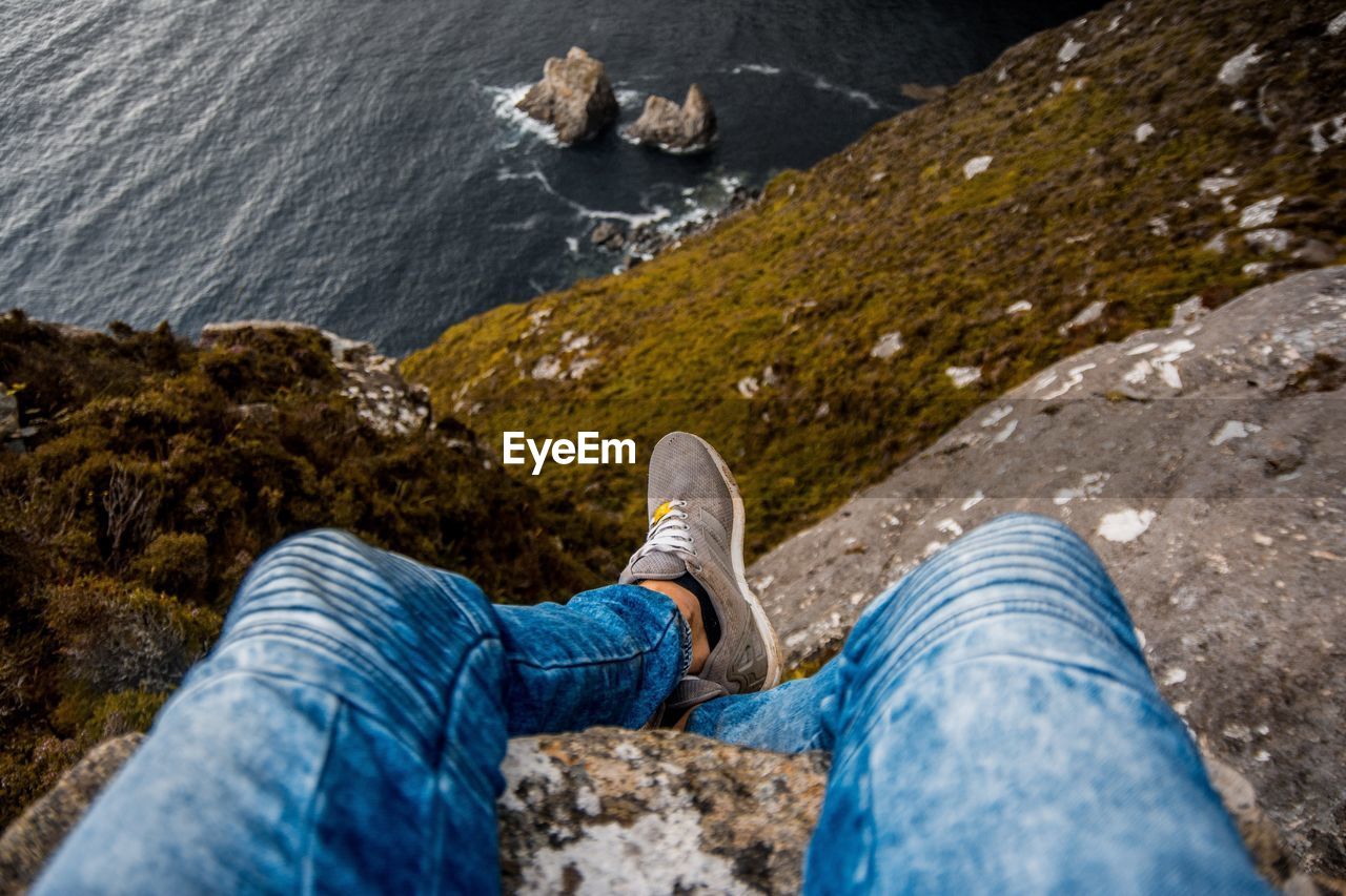 Low section of person sitting on mountain