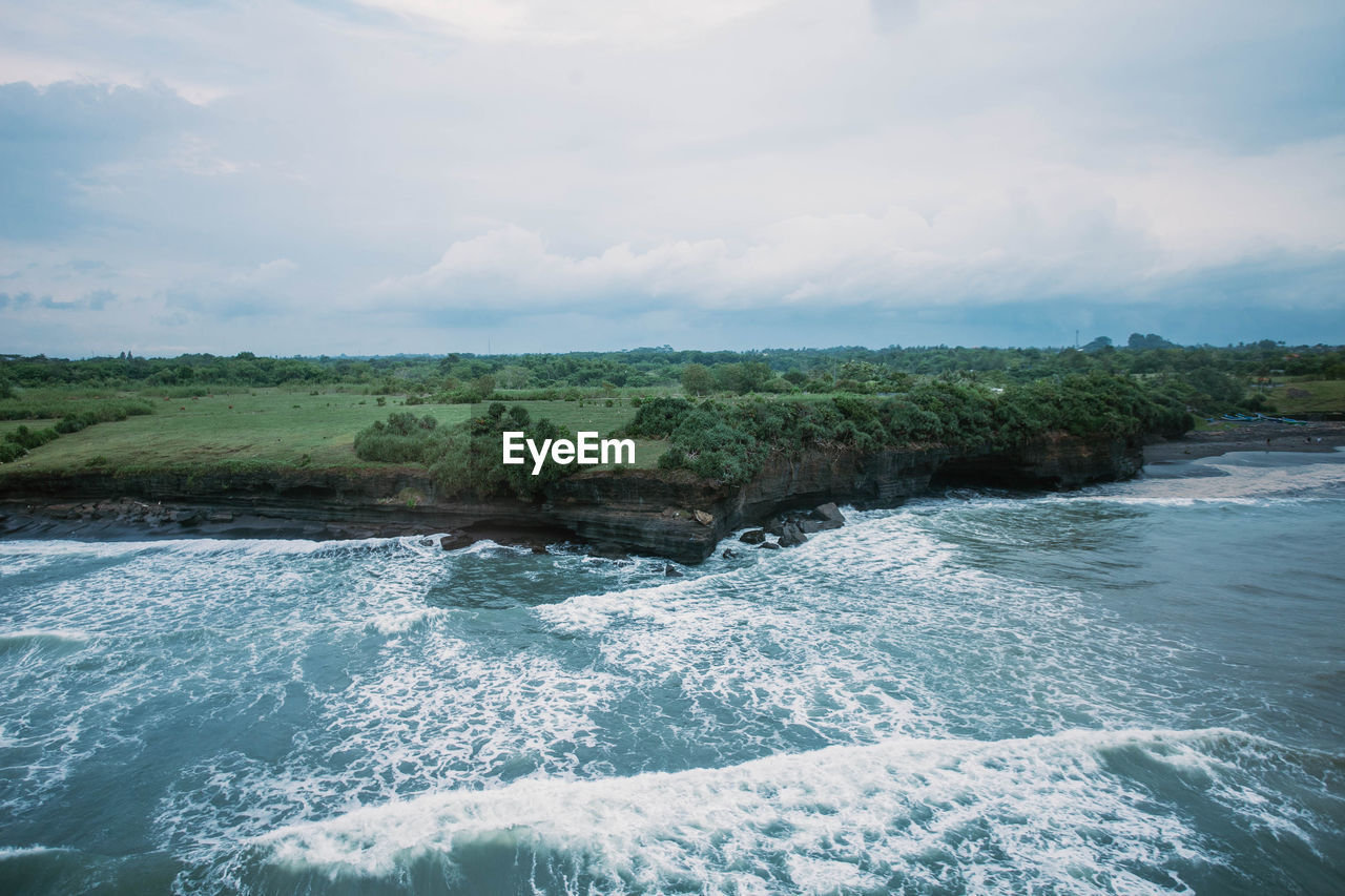 SCENIC VIEW OF SEA BY WAVES AGAINST SKY