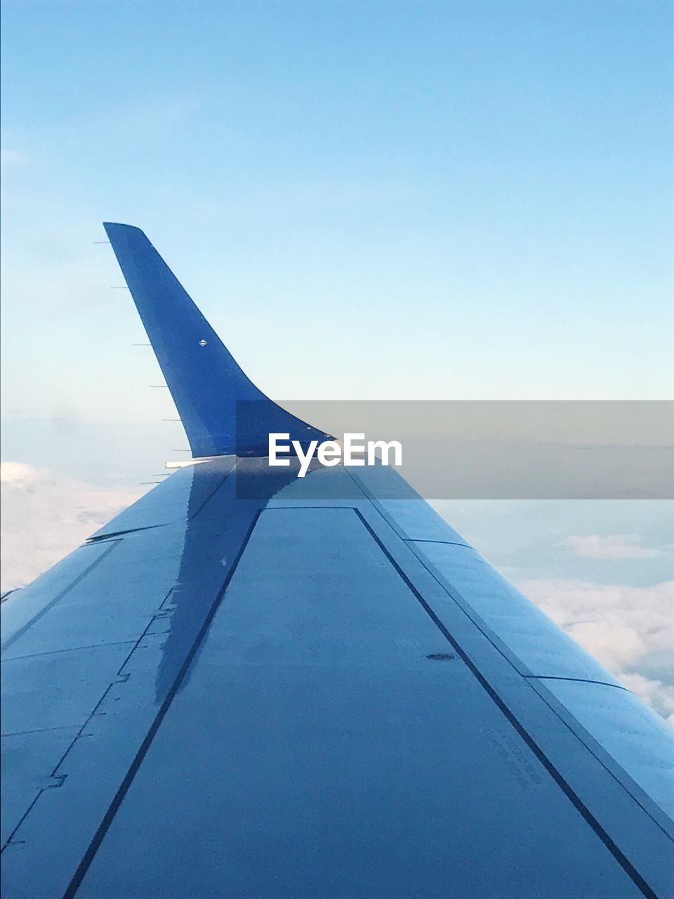 CLOSE-UP OF AIRPLANE WING AGAINST CLEAR SKY