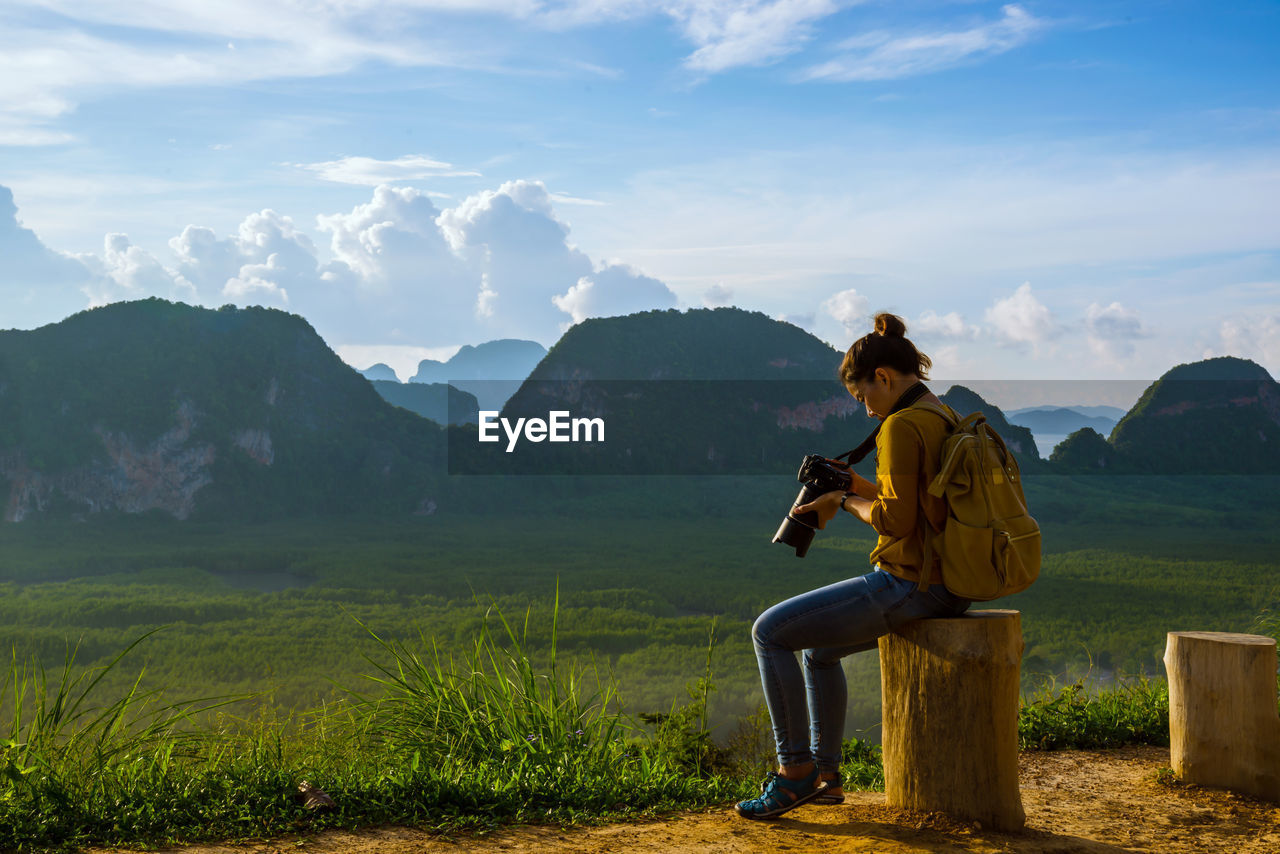 MAN LOOKING AT MOUNTAIN AGAINST SKY
