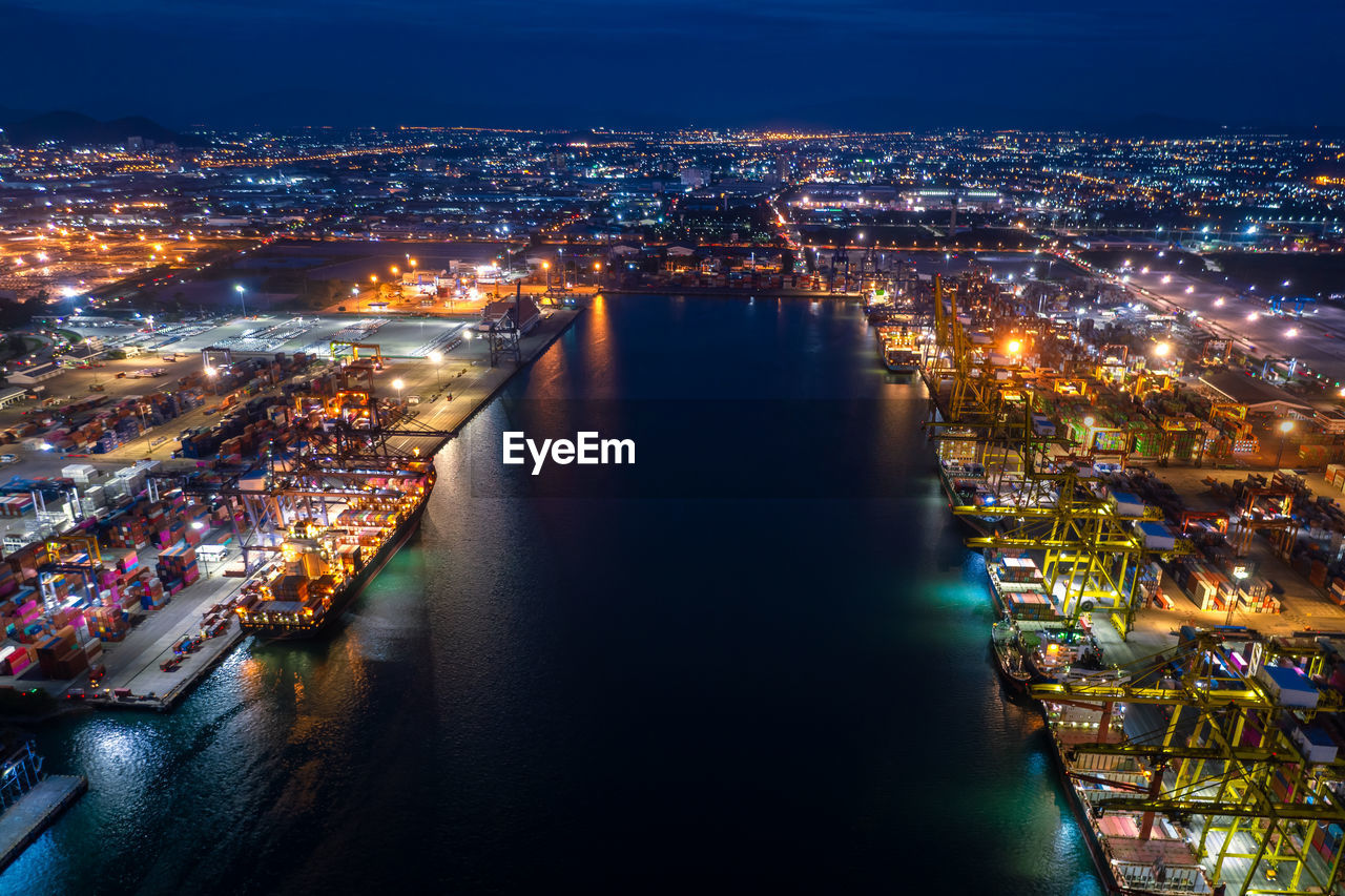 Night scene container ship loading and unloading in deep sea port, aerial view of business service 