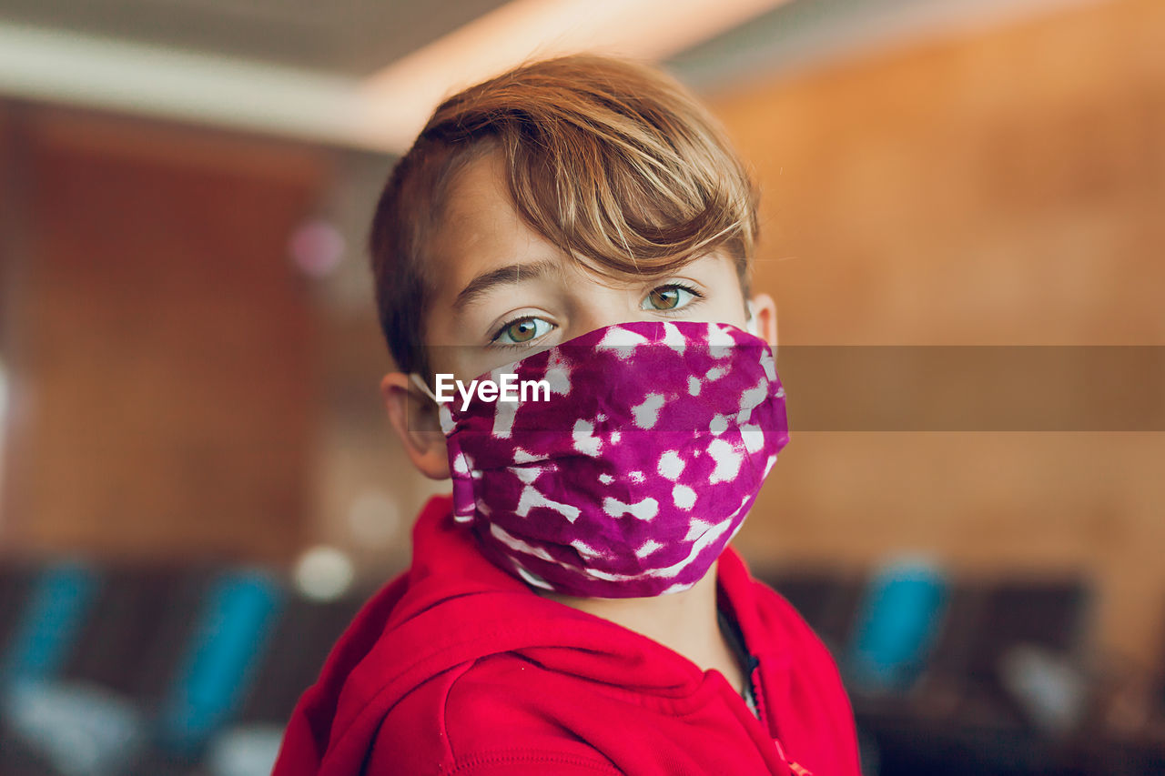 Close up of young boy wearing a mask at airport.