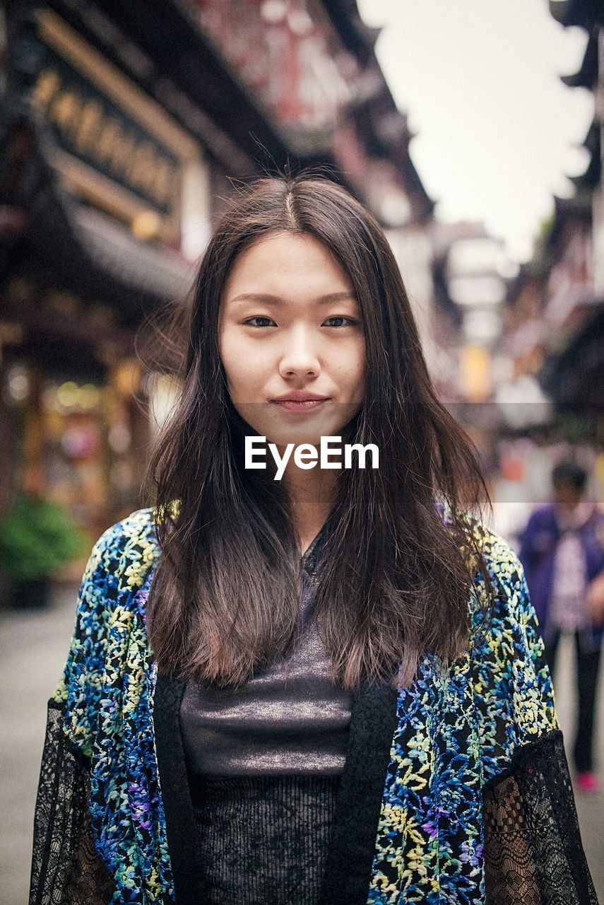 PORTRAIT OF HAPPY YOUNG WOMAN IN CITY