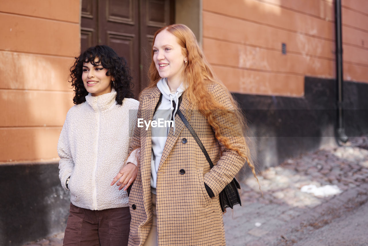 Smiling young women walking in street