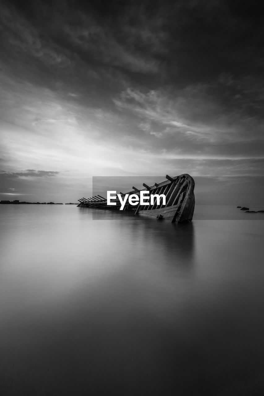 Scenic view of shipwreck sinking at dusk