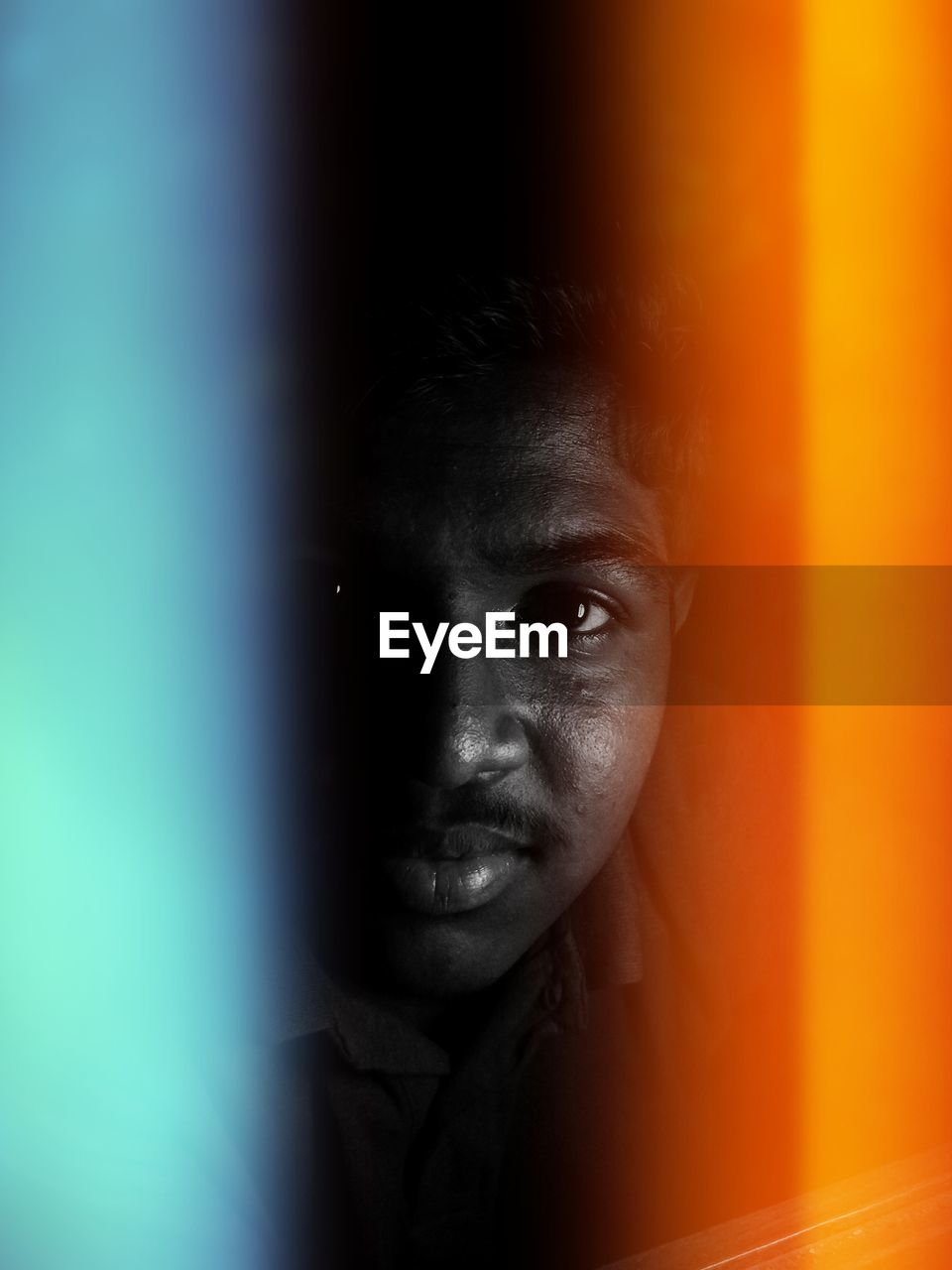 Close-up portrait of young man against black background