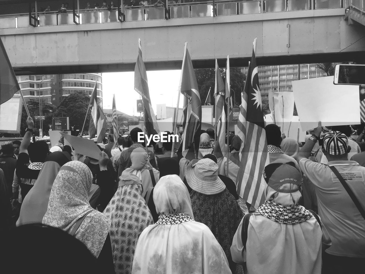 REAR VIEW OF PEOPLE STANDING IN FRONT OF BUILDING