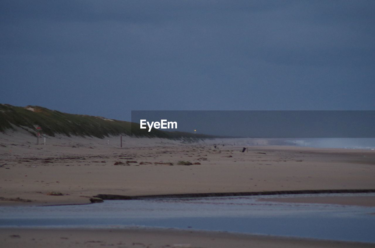 SCENIC VIEW OF SAND DUNES AGAINST SKY