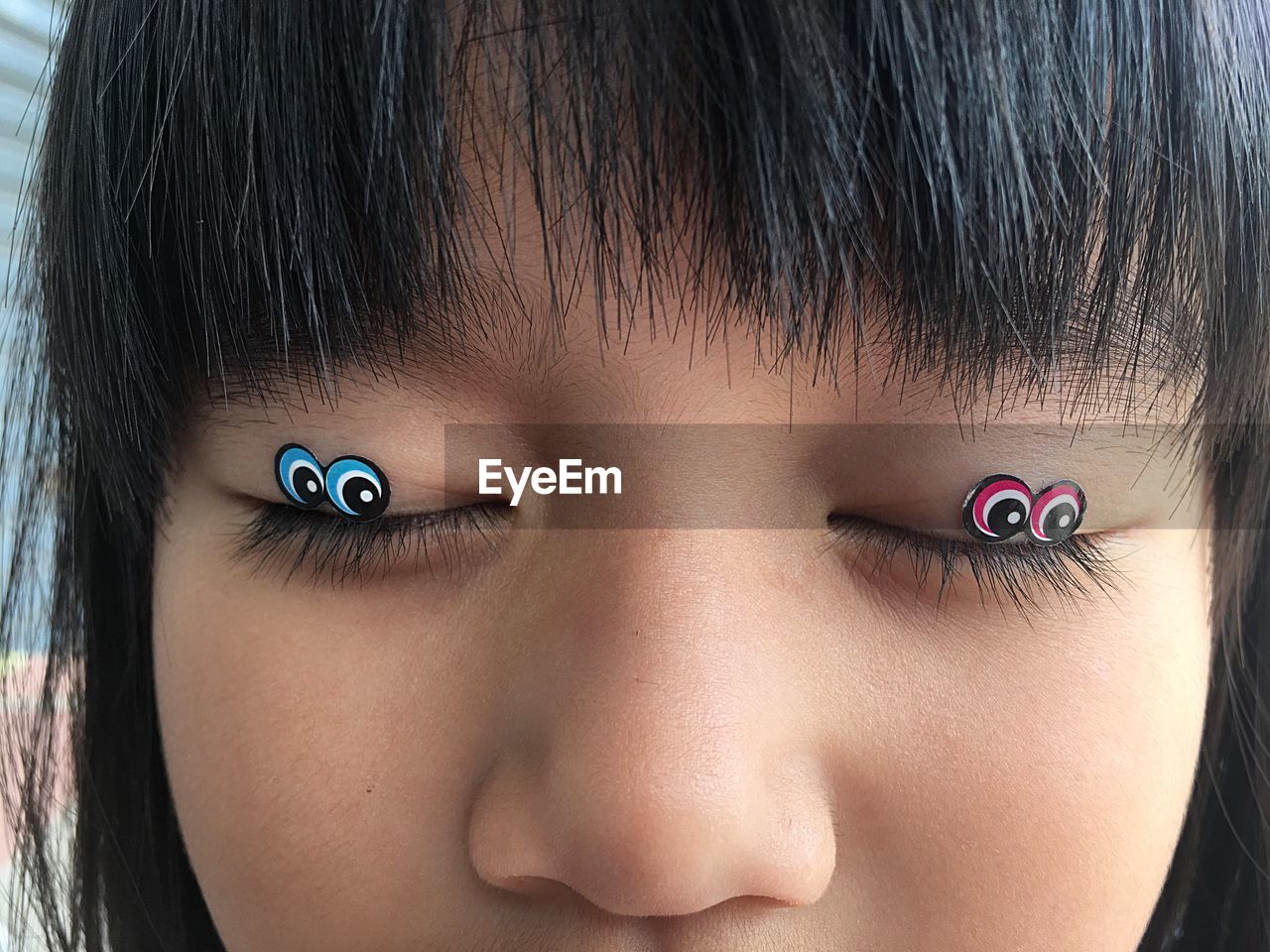 Close-up of girl with stickers on eyes
