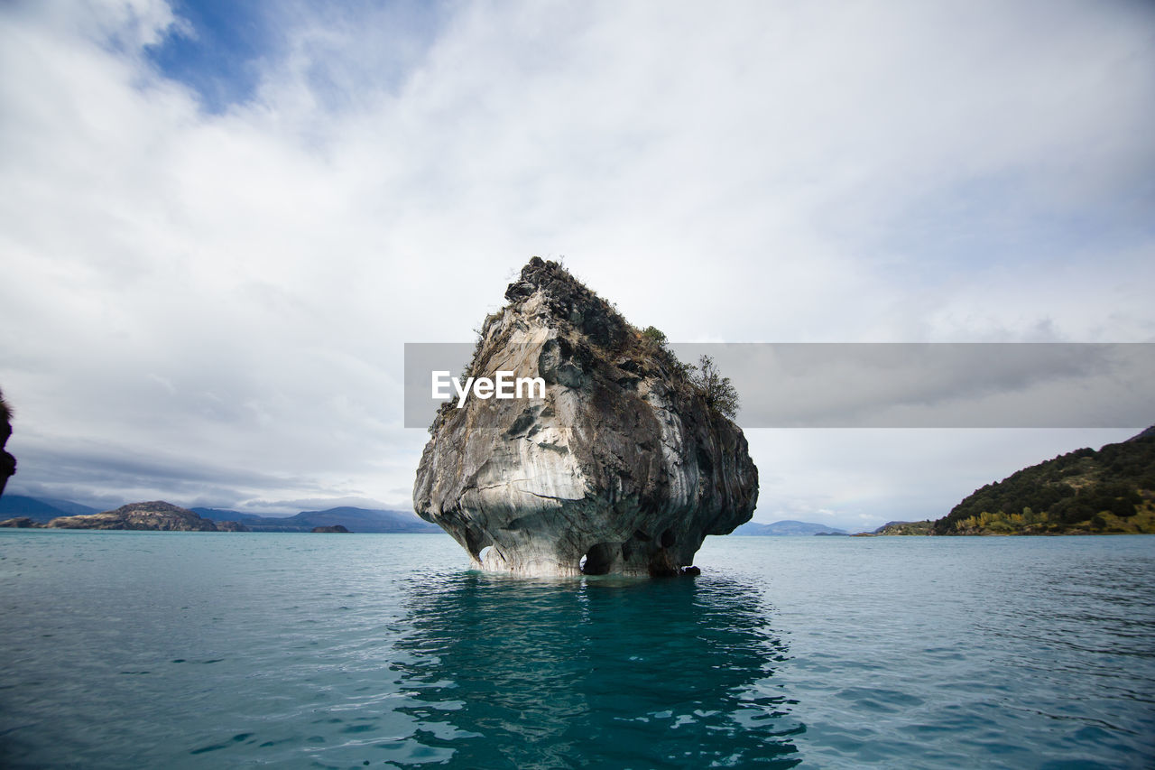 Rock formation in sea against sky