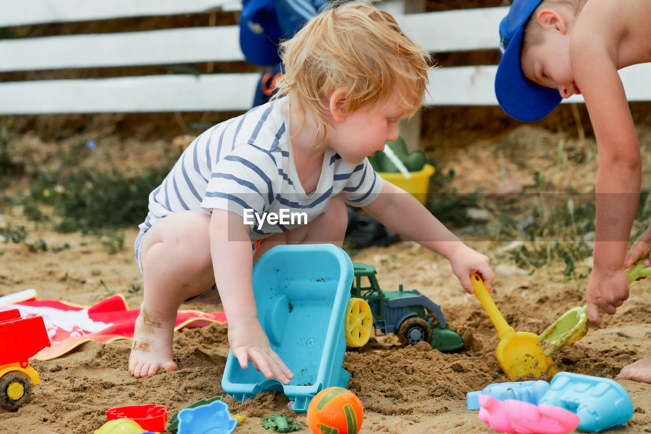 high angle view of boy playing with toys while standing on field