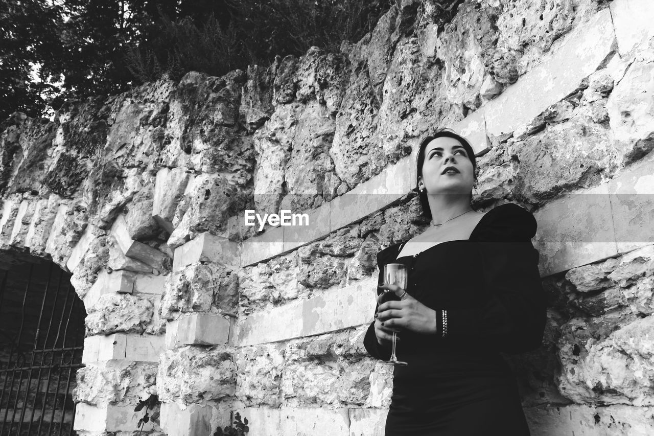 Low angle view of woman standing against wall