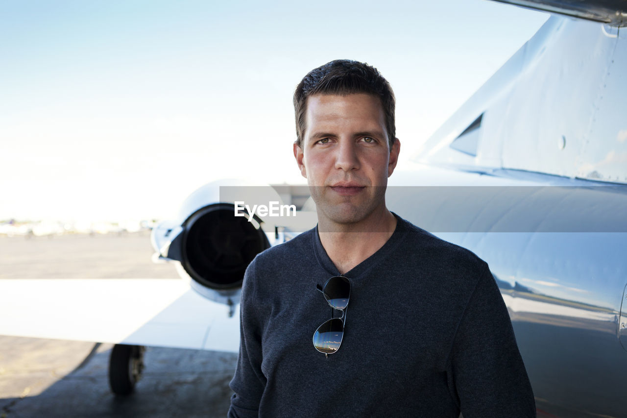 Portrait of confident man standing at airfield