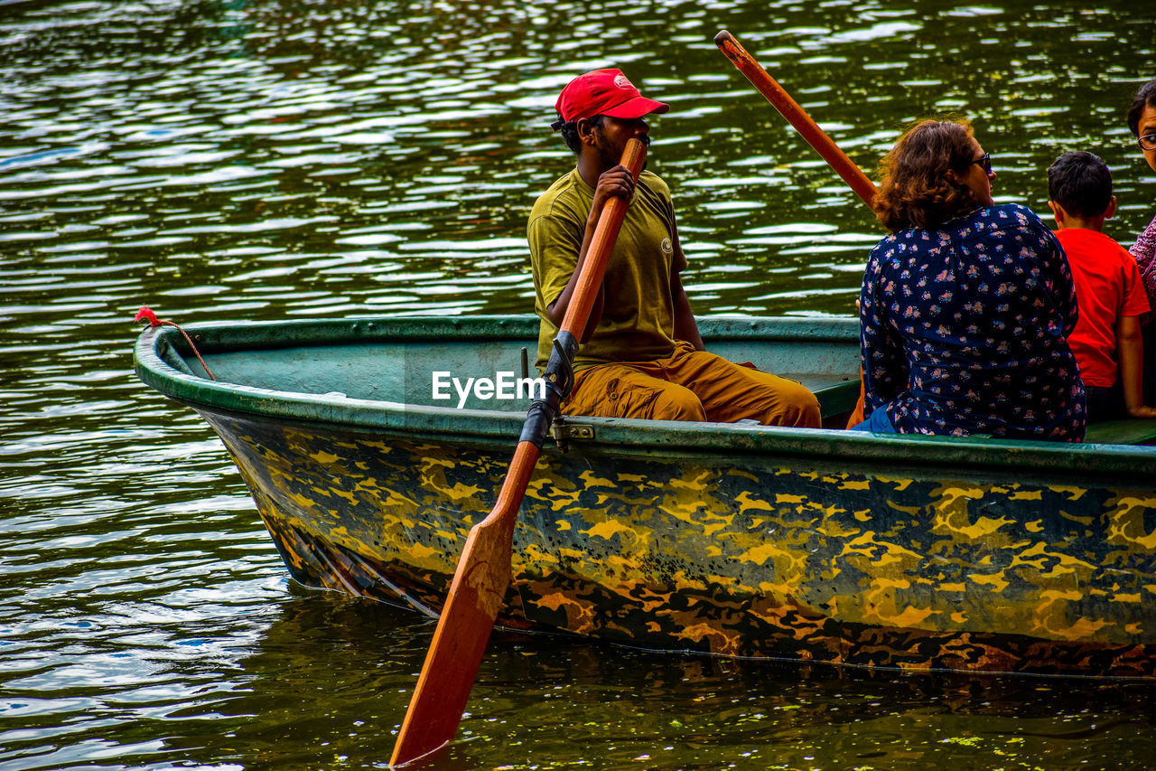 People sitting in boat on lake