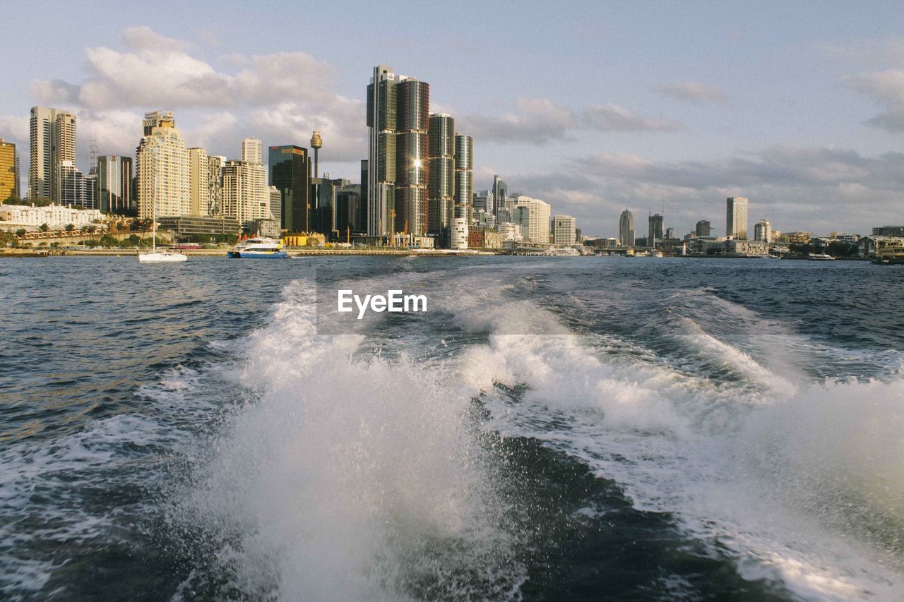 Scenic view of sea and cityscape against sky