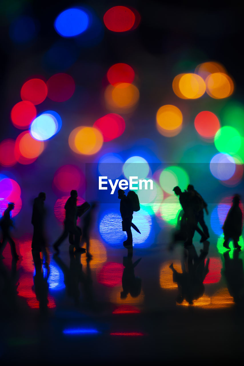 Silhouette of people walking at night