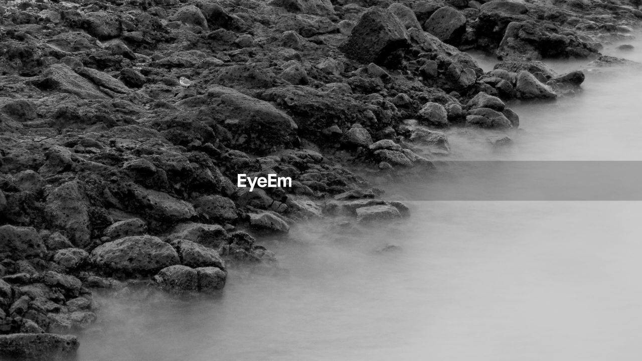 SCENIC VIEW OF RIVER AMIDST ROCKS AGAINST SKY