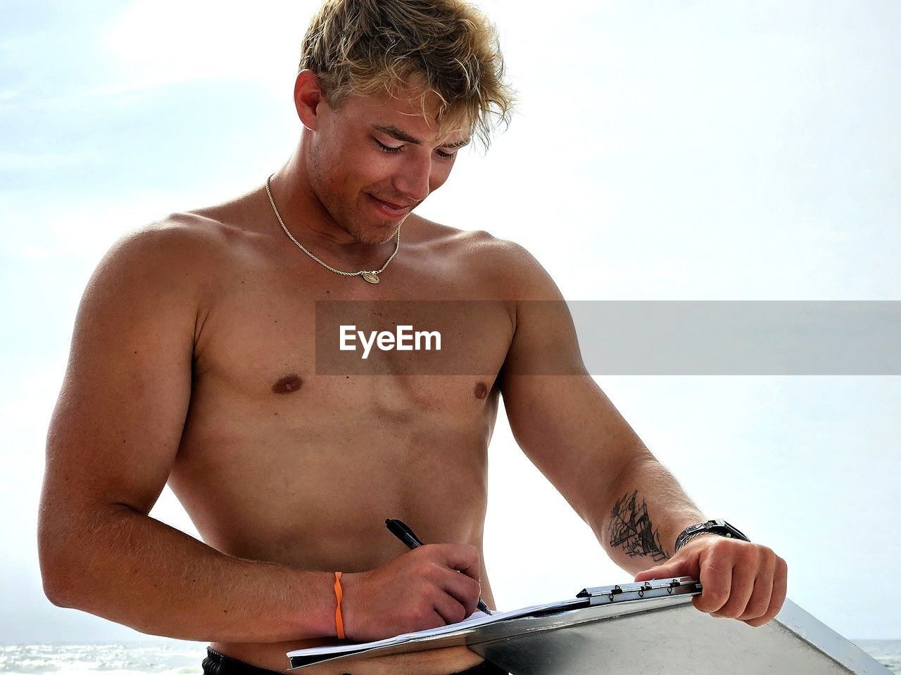 Portrait of shirtless man standing against white background