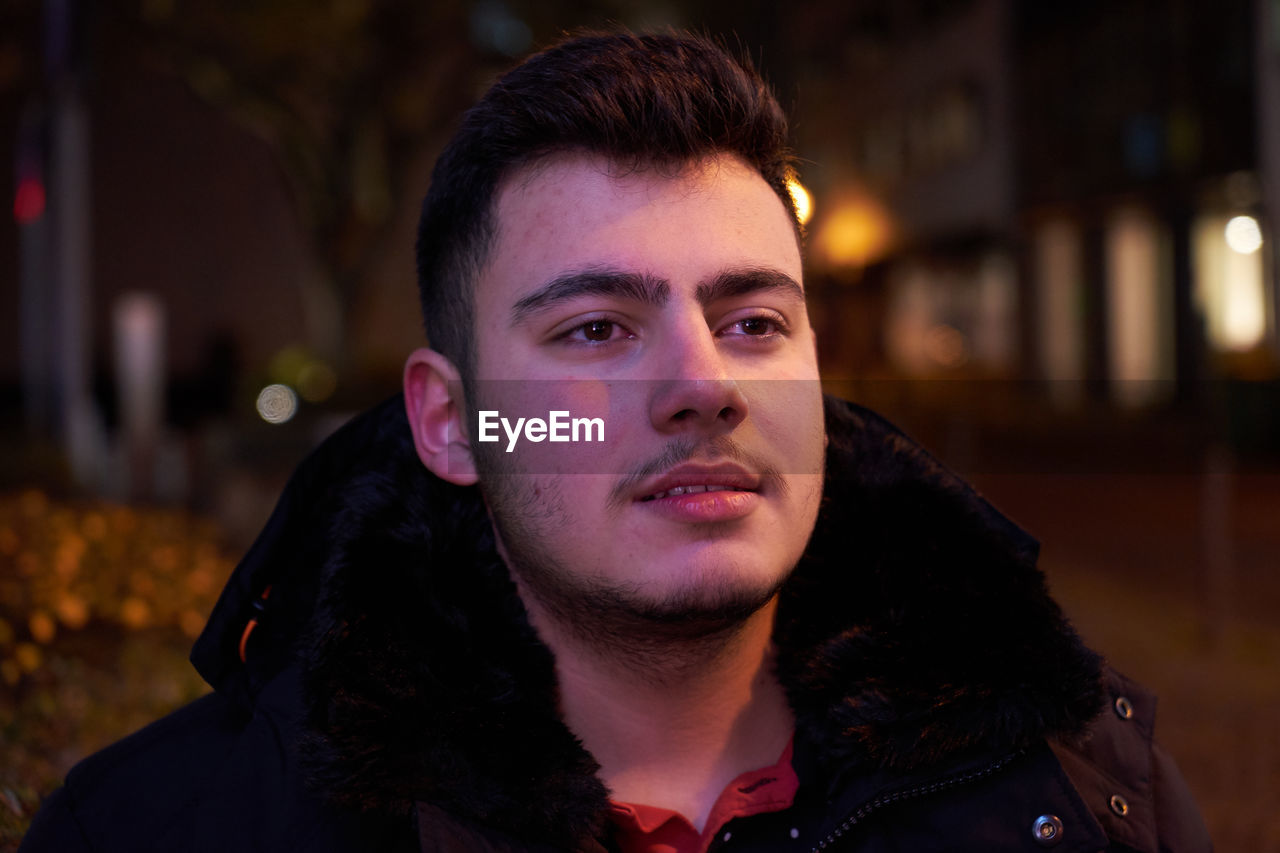 Thoughtful teenage boy standing outdoors
