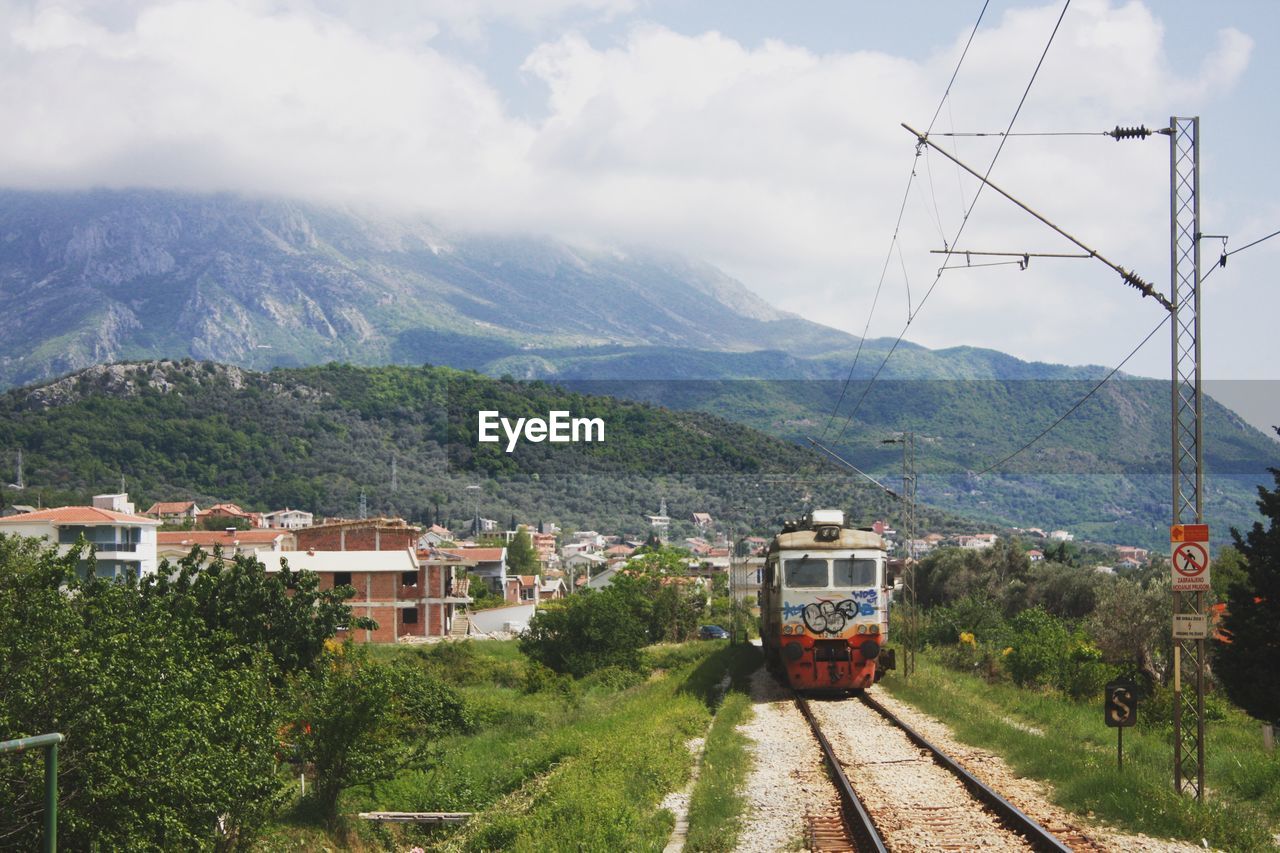 HIGH ANGLE VIEW OF RAILROAD TRACKS AGAINST MOUNTAINS