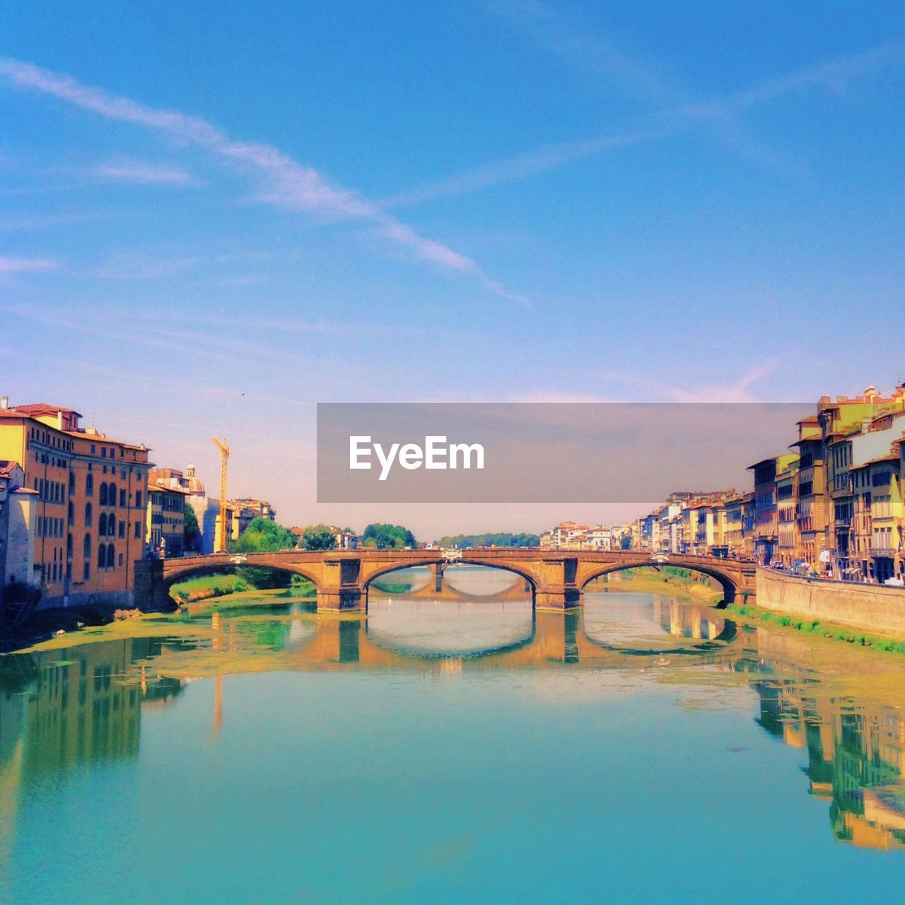 Bridge over river amidst buildings against sky